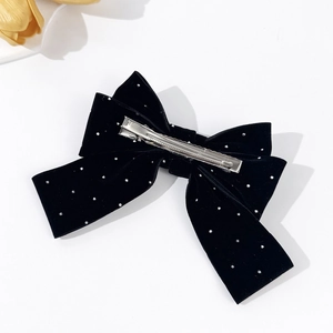 Elegant black velvet bow hair clip with sparkling rhinestones on a white background