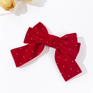 Detailed macro view of red velvet bow hair clip with sparkling silver rhinestones