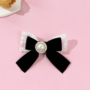 Detailed macro view of a vintage velvet bow hair clip with lace and a central faux pearl