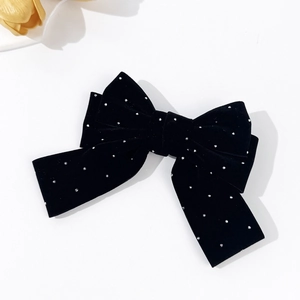 Detail of elegant black velvet bow hair clip with sparkling silver rhinestone accents