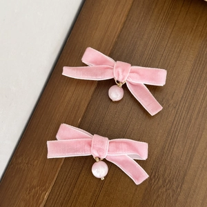 Sweet pink velvet bow hair clips with cat-eye pearl charms on a wooden display tray