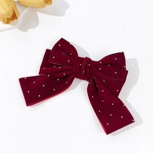 Detail view of burgundy velvet bow hair clip with sparkling silver rhinestones and soft texture