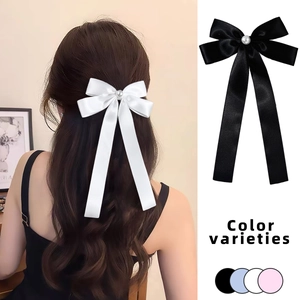 Detail showing the satin bow hair clip with pearl center and color variety options