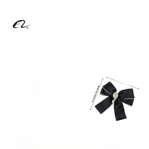 Detail view of handmade black ribbon bow hair clip with rhinestones and faux pearl drop charm