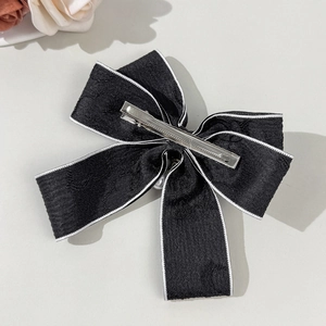 Elegant black jacquard bow hair clip with white piping and silver metal duckbill clip