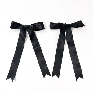 Detail of black satin ribbon bows with elegant long streamers and swallowtail cut design