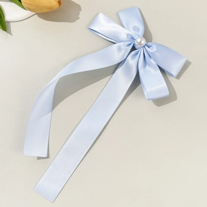 Elegant light blue satin bow hair clip with a center pearl and long flowing ribbons