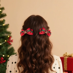 Détail de pinces à cheveux nœuds de Noël rouges et verts avec cloches sur cheveux