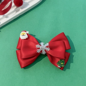 Macro d'un nœud papillon de Noël rouge avec Père Noël et flocons de neige décoratifs
