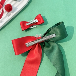 Christmas hair clips set with red and green bows and snowflake charms on green background