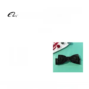 Detail view of black velvet bow hair clip with sparkling glitter and 15.5cm size markings