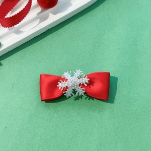 Detail of red ribbed bow hair clip featuring a sparkling silver snowflake centerpiece ornament