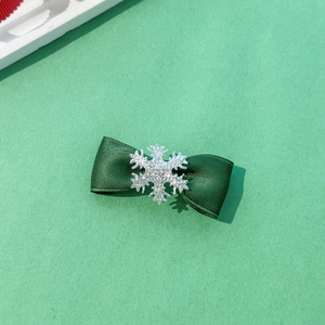 Detail of Christmas green ribbed ribbon hair clip with a silver snowflake glitter accent