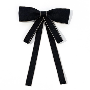 Detailed view of black ribbon bow with gold metallic edge stitching and long streamers