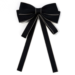Detail of black JK bow tie with textured fabric and fine gold stitching for school uniforms