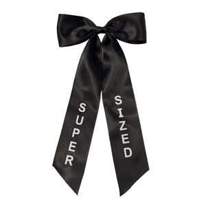 Elegant oversized black satin bow hair clip with vertical SUPER SIZED letter print
