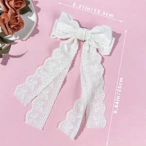 Romantic white lace bow hair clip with embroidery details on a pink background