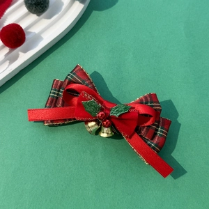 Barrette de Noël avec nœud à carreaux rouges, clochettes dorées et baies de houx