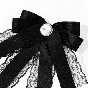 Black satin and lace bow brooch with pearl pendant and metal pin on white background