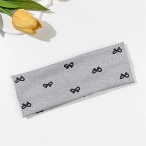 Detail of grey elastic fabric headband featuring black bow prints and yellow tulip decor