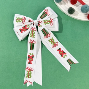 Détail d'un nœud papillon de Noël blanc avec motifs cadeaux de fête sur une surface verte