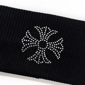 Close-up of ribbed knit headband with rhinestone cross emblem for street style look