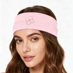 Detail showing pink ribbed yoga headband with a sparkling rhinestone flower pattern