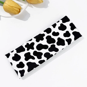 Vista detallada de la diadema elástica con estampado de vaca y suave textura de punto