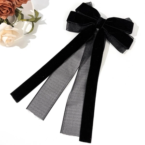 Detailed view of the layered black velvet and mesh bow hair clip with long ribbons