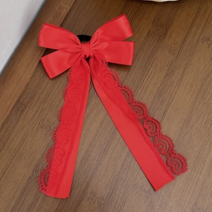 Elegant red bow hair tie with satin ribbon and delicate lace streamers for women