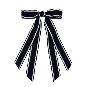 Pince à cheveux double nœud noir élégante avec surpiqûres blanches et longs rubans sur fond blanc