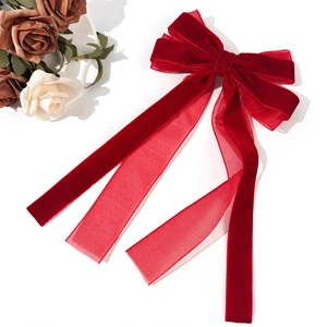 Elegant red velvet and mesh ribbon bow hair clip with long streamers on a white background
