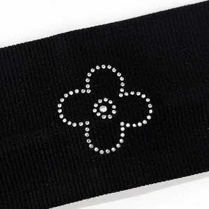 Close-up of black ribbed knit headband with sparkling rhinestone flower detail