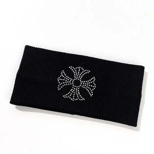 Detail of black ribbed knit headband featuring a sparkling rhinestone cross decoration