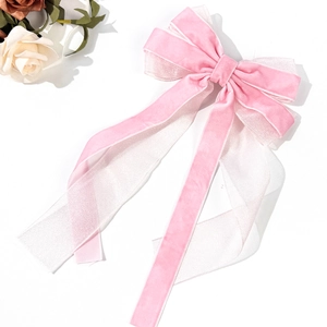 Detail of pink velvet and organza ribbon bow hair clip with elegant long streamers