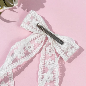 Barrette à cheveux élégante en dentelle blanche avec broderie sur fond rose clair