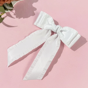 Gros plan sur le nœud papillon en satin blanc avec bords volantés élégants et texture lisse