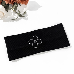 Detail shot of black elastic yoga headband with rhinestone flower design on white background