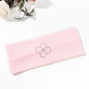 Pink ribbed yoga headband with rhinestone flower design and soft elastic texture