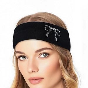 Detail of black elastic headband featuring a rhinestone bow design on female model