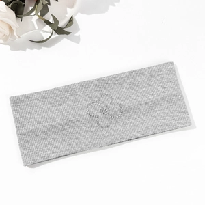 Detailed macro view of grey knitted elastic headband with sparkling rhinestone flower