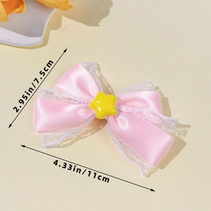 Detailed view of pink satin bow hair clip with white lace trim and yellow star center
