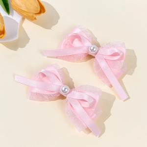 Vue détaillée des pinces à cheveux roses avec dentelle et décoration de perle centrale