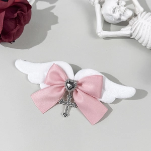Detalle de pinza Goth Lolita con alas blancas, lazo rosa y colgante de cruz plateada