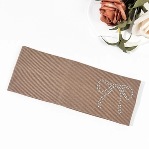 Macro shot of brown ribbed knit headband with elegant silver rhinestone bow detail