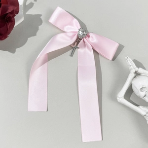 Pink satin bow hair clip with heart rhinestone and silver metal cross pendant detail