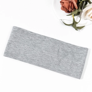 Detailed close-up of grey ribbed knitted headband with rhinestone bow design and soft texture