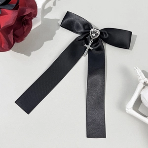 Close-up of gothic black satin bow hair clip with silver heart rhinestone and cross