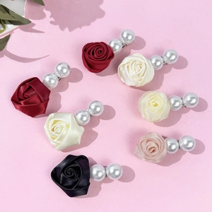 Détail des pinces à cheveux rose en satin coloré avec perles élégantes et barrettes métal