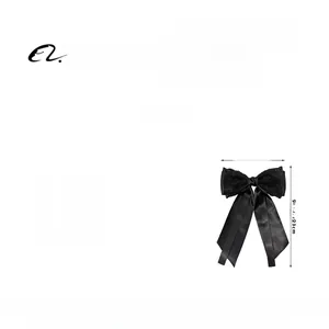 Détail d'une pince à cheveux en satin noir avec dentelle, mesurant 15,5 cm sur 23 cm